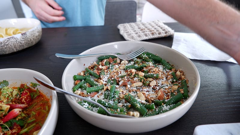 plate of green beans with almonds, lemon zest, and cotija. 