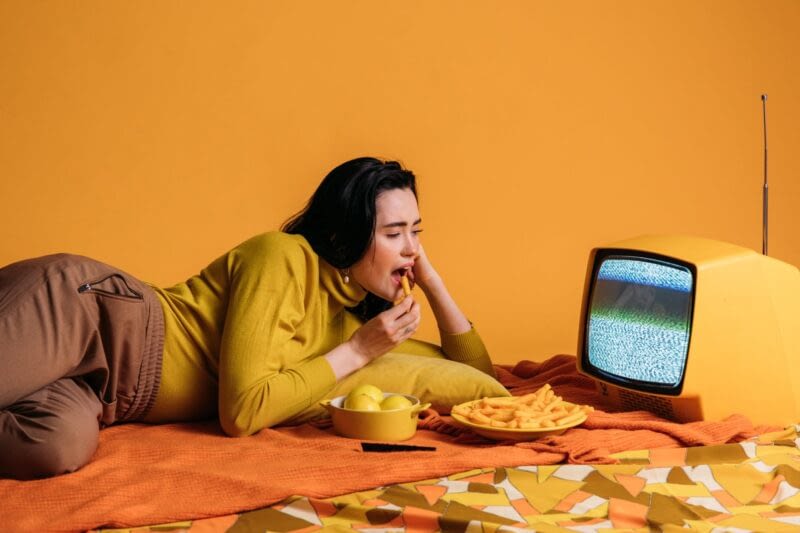 Girl eating french fries in front of tv static